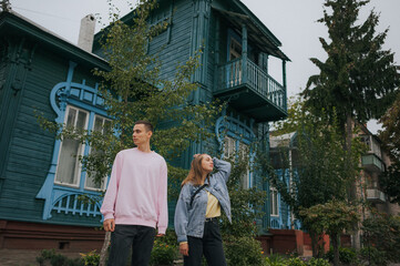 A happy young couple in love, a boy and a girl, on a walk in the city, hugging and walking. Urban European love story and photo shoot