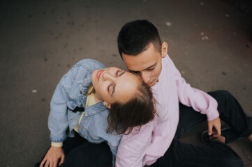 A happy young couple in love, a boy and a girl, on a walk in the city, hugging and walking. Urban European love story and photo shoot