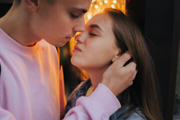 A happy young couple in love, a boy and a girl, on a walk in the city, hugging and walking. Urban European love story and photo shoot