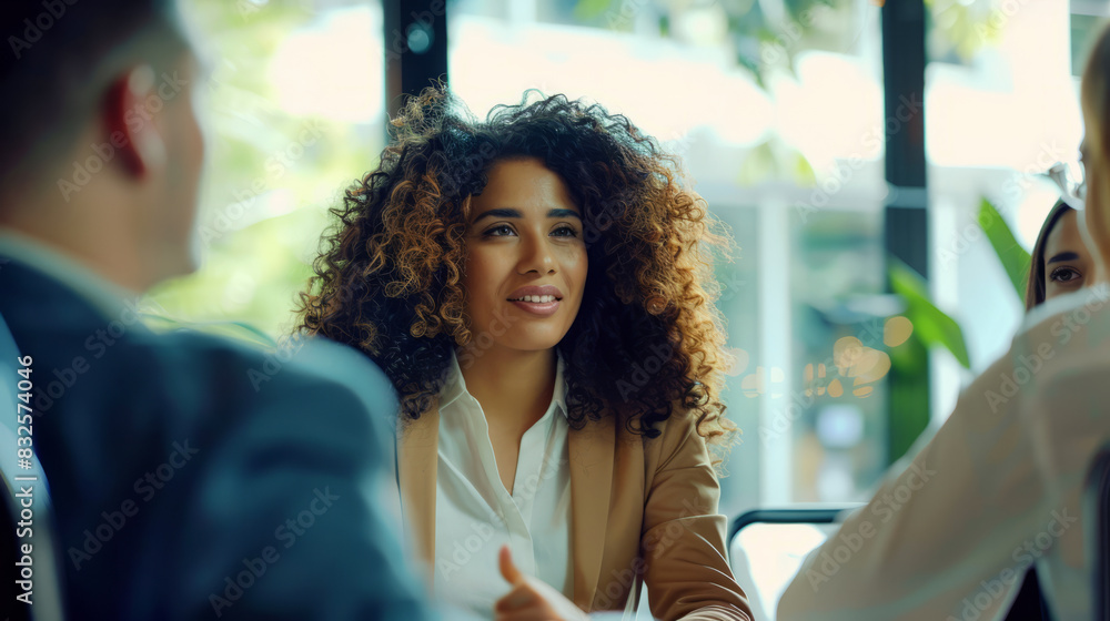 Wall mural a hispanic businesswoman discussing a project with colleagues in a modern conference room