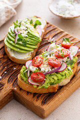 Fresh avocado toasts on wooden board