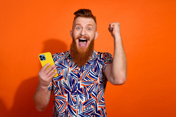 Photo of lucky excited guy dressed print shirt winking winning game modern device empty space...