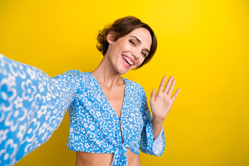 Photo of cheerful positive girl with bob hairdo dressed print blouse making selfie say hi waving...