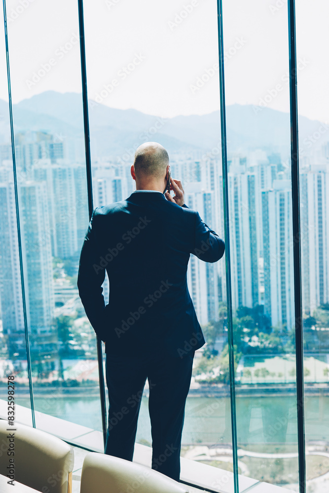 Poster back view of male entrepreneur in formal wear talking via smartphone device about results of ssucces