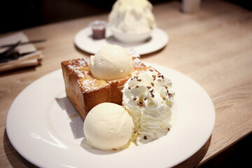 white bingsu snow milk based Korean shaved ice dessert with sweet toppings serve chocolate sauce and honey toast with icecream and wiping cream 