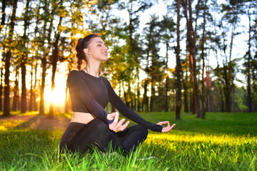 A young woman practices meditation in a serene forest during sunrise, promoting peace and mindfulness.