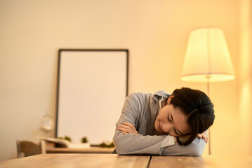 暖色の室内灯の部屋でリラックスした表情の女性