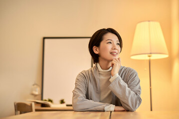 暖色の室内灯の部屋でリラックスした表情の女性