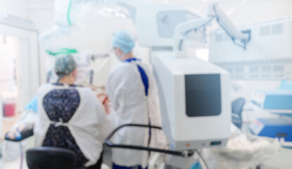 Abstract medical blurred background of operating room with blue light, patient lies on table,...