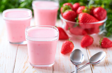 homemade strawberry smoothie in a glass jars with fresh strawberry on a white table, selective focus.