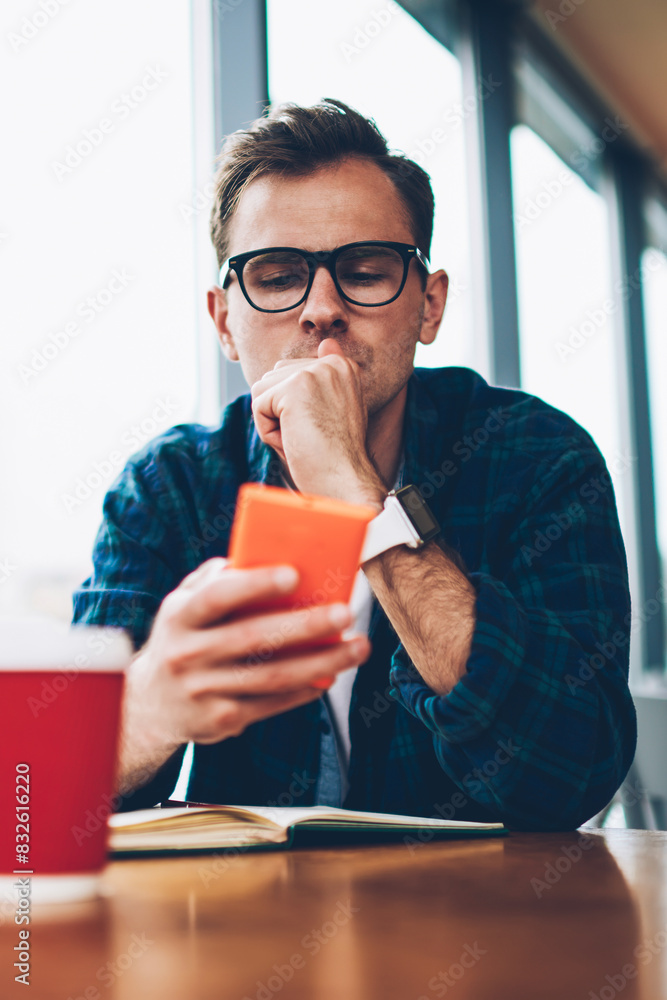 Poster handsome pensive smart male student dressed in trendy outfit texting email message using application