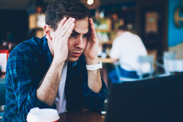 Good looking intelligent student dressed in casual clothing deeply thinking while preparing for...