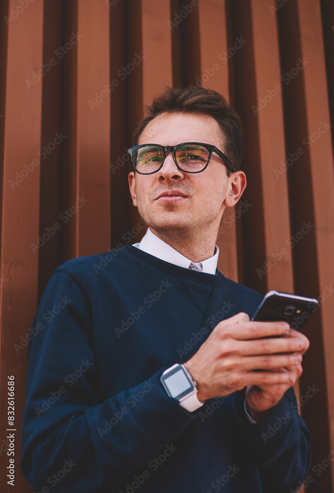 Poster half length portrait of handsome male student in trendy eyeglasses downloading popular application f