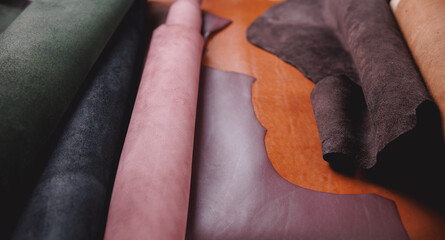 Banner of tailor, leather rolls of natural color in workshop. Materials for DIY handmade craft