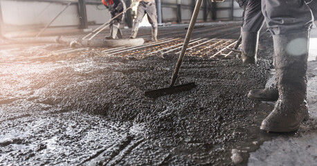Workers work on concrete concreting floors of buildings in construction site, pouring cement