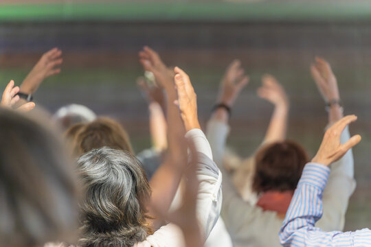 Group of older people raising their arms in a meditation class