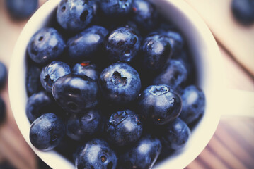 Fresh blueberries in a white cup top view