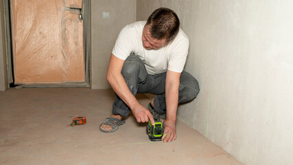 Builder worker makes repairs in the apartment. House renovation. Professional measuring device