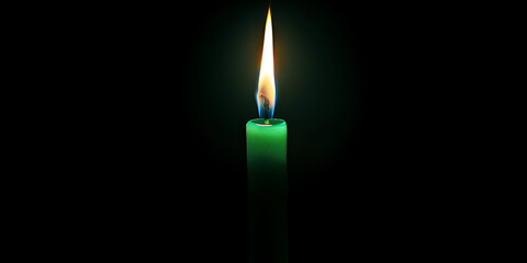 A green candle is lit against a black background