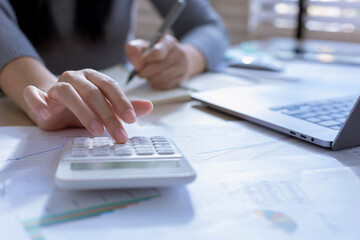 Business woman or accountant working on calculator to calculate business data in modern office....