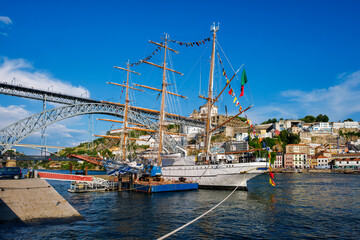 View of Vila Nova de Gaia city with a sailing ship and Dom Luis I bridge over Douro river. Porto,...