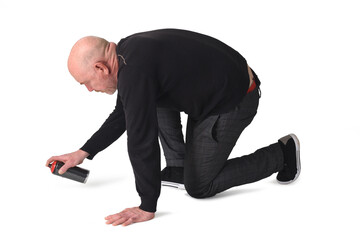 side view of a man painting on the floor with spray on white background