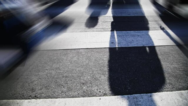 Shadows of people walking on the crosswalk