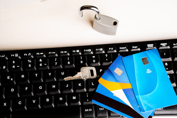 Online shopping security concept, credit cards on a computer keyboard and a padlock with a key.
