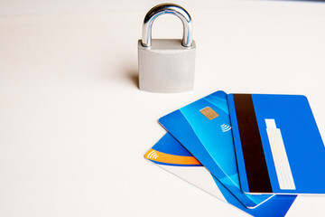 Concept of expense control, a closed padlock with credit cards on a white background.
