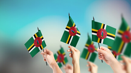 A group of people are holding small flags of Dominica in their hands.
