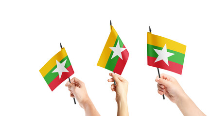 A group of people are holding small flags of Myanmar in their hands.