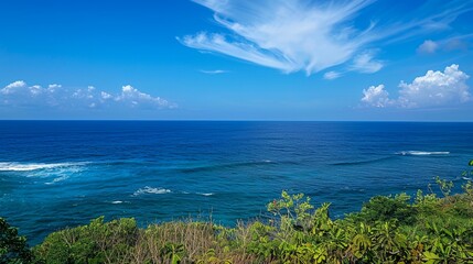 Fototapeta premium a view of the ocean from a hill top with a blue sky