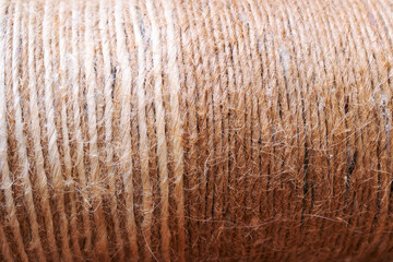 The image shows a detailed view of a spool of brown yarn
