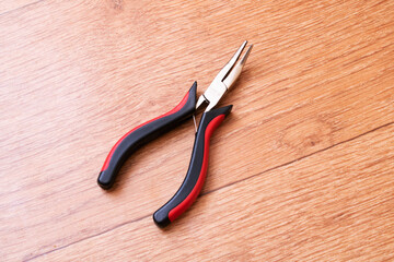 A pair of pliers on a table with other tools like snips and slip joint pliers