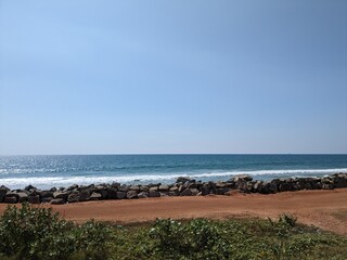 A serene beach scene with clear blue skies and calm ocean waters.