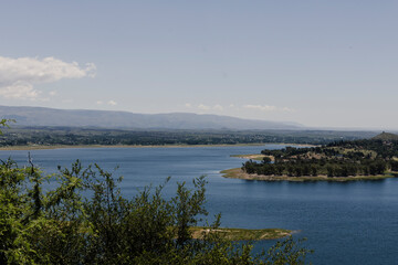 Paisaje de lago azul con montaña arboles y vegetacion