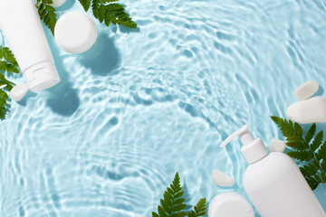 White cosmetic bottles and fern leaves arranged on a rippling water surface, creating a fresh and natural aesthetic. Perfect for advertisements, skincare blogs, and beauty product promotions
