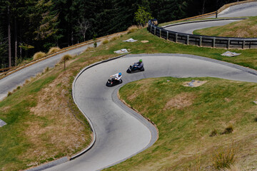 queenstown, New Zealand - February 3, 2019 : Luge riders navigating a sharp curve