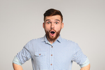 Astonishment and shock. Surprised bearded man wearing casual shirt posing with shocked look on...