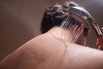 A man is taking a shower, enjoying the clean water to ensure good hygiene and relaxation