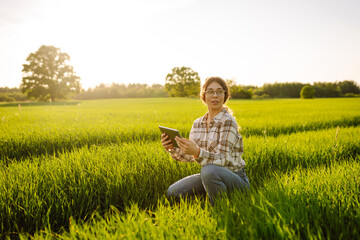 Smart farm. Woman Farmer with tablet in green field. Farming business and irrigation concept.