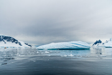 Horizontally composed shot of the rugged mountains of the Antarctic Peninsula and their reflection...