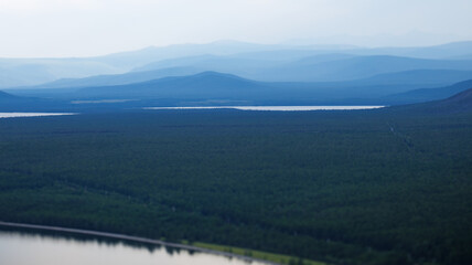 A lake nestled in a serene forest with towering mountains in the backdrop