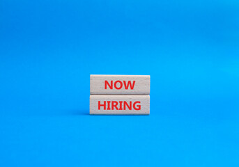 Now Hiring symbol. Concept word Now Hiring on wooden blocks. Beautiful blue background. Business and Now Hiring concept. Copy space