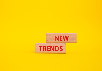 New Trends symbol. Wooden blocks with words New Trends. Beautiful yellow background. Business and...