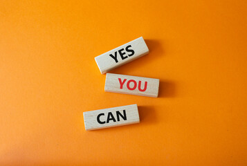 Yes You Can symbol. Concept word Yes You Can on wooden blocks. Beautiful orange background....