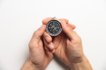 compass in hands on a white background close-up. male hands hold modern compass in retro style