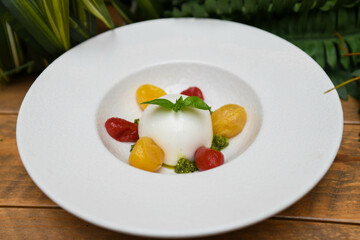 Ensalada caprese con burrata mozarella, tomates cherry y salsa pesto
