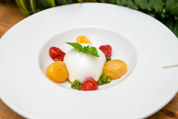 Ensalada caprese con burrata mozarella, tomates cherry y salsa pesto
