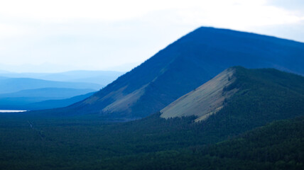 A picturesque scene of a treecovered mountain under a clear blue sky